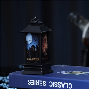 Detail of vintage Halloween lantern featuring pumpkin and bat prints on a blue book