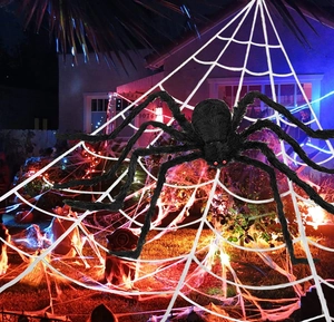 Giant black hairy spider with red eyes on large white outdoor web for Halloween yard decor