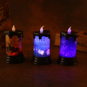 Tre candele LED di Halloween con motivi luminosi di zucca e teschio su legno scuro