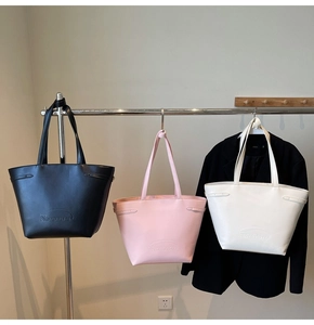 Close-up of minimalist tote bags in black, pink, and white with Noronoro embossed logo
