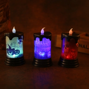 Dettaglio di tre candele LED di Halloween con motivi di zucca e strega che brillano al buio