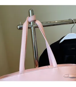 Close-up of pink tote bag showing reinforced shoulder straps and side buckle detail