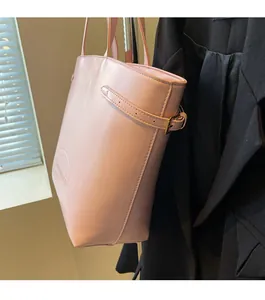 Detail of pink leather tote bag featuring adjustable side straps and embossed logo design