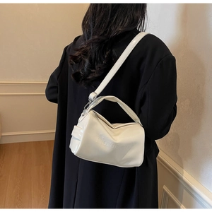 Close-up of white leather underarm bag with Honomon embossed logo and silver hooks