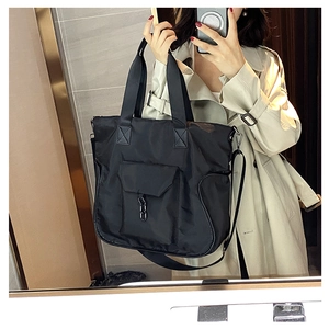 Black waterproof nylon tote bag with front buckle pocket and detachable shoulder strap