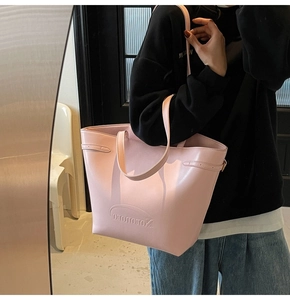 Close-up of a pink leather tote bag featuring the Noronoro embossed letter logo