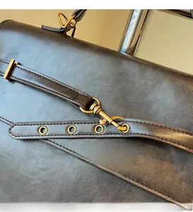 Detail of premium lychee texture leather and durable golden metal buckle on backpack