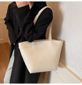 Close-up of the embossed Noronoro logo on a cream-white tote bag with smooth texture