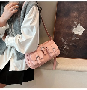 Detailansicht einer rosa Umhängetasche mit drei Pattentaschen und Silberschnallen