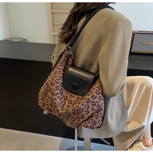 Detail of leopard print tote bag featuring black leather flap and snap closure