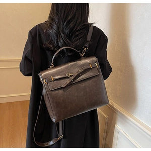Detail of vintage faux leather backpack with gold buckle and adjustable shoulder straps