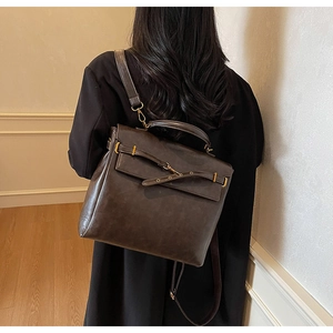 Detail view of the vintage dark brown leather backpack with belt buckle on the flap