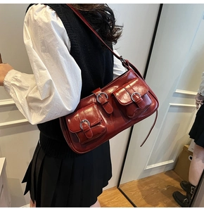 Nahaufnahme der tiefroten glänzenden Schultertasche mit doppelten Fronttaschen