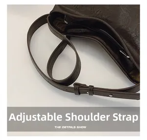 Détails de la bandoulière réglable et boucle en métal sur le sac seau en cuir marron