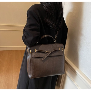 Detail of vintage dark brown faux leather backpack with retro gold metal buckle