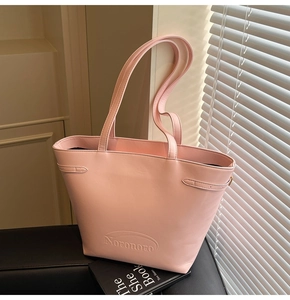 Detail of pink faux leather tote bag with Noronoro embossed logo and buckle accents