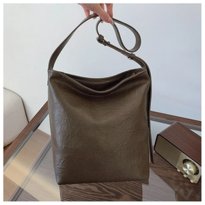 Vue détaillée du sac hobo plissé marron foncé avec bandoulière et logo de la marque