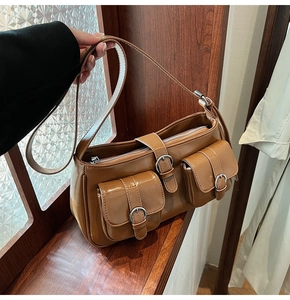 Detail der karamellbraunen Schultertasche mit Cargo-Taschen und silbernen Schnallen