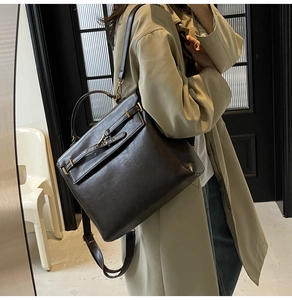 Detail of vintage dark brown faux leather backpack with metallic buckle on trench coat