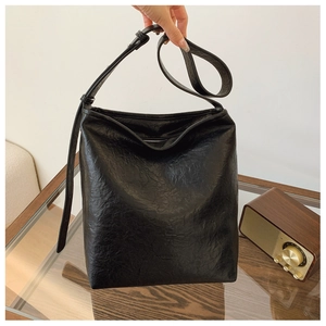 Détails du sac hobo noir avec texture plissée et logo embossé discret