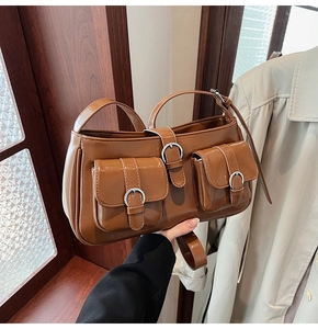 Detail einer braunen Vintage-Leder-Schultertasche mit Schnallentaschen und Karamell-Finish