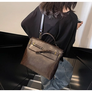 Model wearing a vintage brown leather backpack on a minimalist staircase background