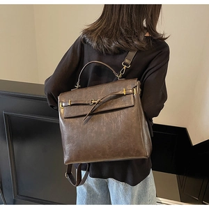 Detail view of vintage dark brown leather backpack showing sturdy handles and side profile