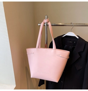 Pink faux leather tote bag with embossed Noronoro logo hanging on a metal rack