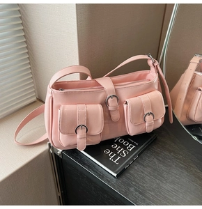 Detail der rosa Schultertasche aus glänzendem Lackleder mit dekorativen Vordertaschen