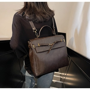 Detail view of the vintage brown faux leather backpack with metallic buckle closure