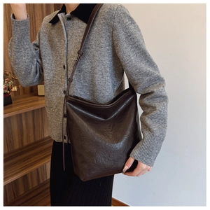 Détail du sac à bandoulière marron foncé vintage avec plis et texture cuir élégante