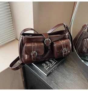 Detail der braunen Vintage-Schultertasche aus glänzendem Öl-Wachs-Leder mit Schnallen