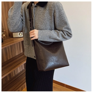 Détail du sac cabas plissé marron foncé dans un cadre de vie intérieur esthétique
