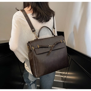 Detail of vintage dark brown faux leather backpack with metallic buckle and sturdy handle