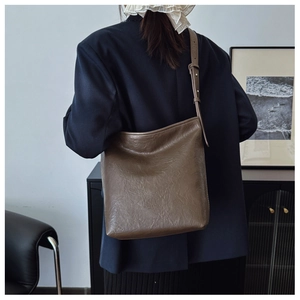 Détails de la texture du cuir plissé vintage et boucle argentée du grand sac à bandoulière