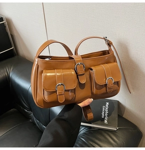 Nahaufnahme braune Vintage Schultertasche mit silbernen Schnallentaschen und Glanzleder