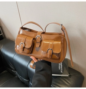 Detailansicht der braunen Kunstledertasche mit silbernen Schnallen und verstellbarem Gurt