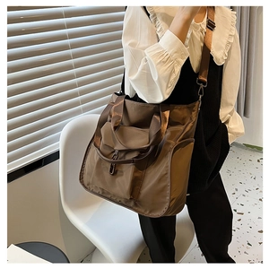 Brown nylon tote bag shown as a crossbody with adjustable strap and multi-pocket design