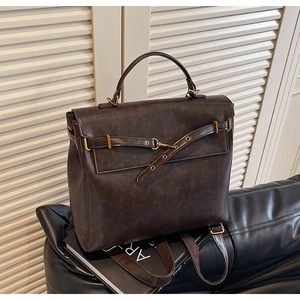 Detailed view of dark brown vintage backpack with premium matte leather and gold hardware