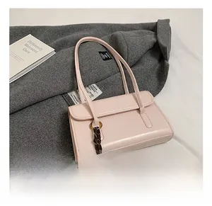 Detail of light pink faux leather shoulder bag with silk scarf and gold ring buckle