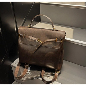 Detail of dark brown vintage faux leather backpack with metallic buckle on stone stairs