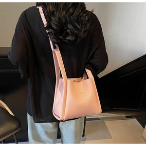 Detailed shot of soft pink lychee grain leather bucket bag with embossed logo