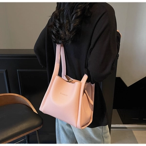 Close-up of pink litchi grain leather tote bag with embossed logo and elegant handles