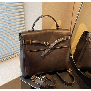 Macro view of retro dark brown textured faux leather backpack with gold buckle hardware