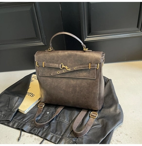 Close-up of vintage dark leather backpack with textured finish and buckle detail