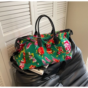 Detail of a large green floral travel bag with traditional peony and phoenix embroidery