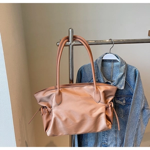 Détail du sac fourre-tout en nylon caramel avec poignées en cuir et cordons latéraux
