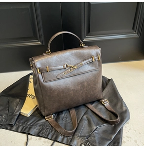 Detail view of dark brown vintage leather backpack with golden metal hardware and strap