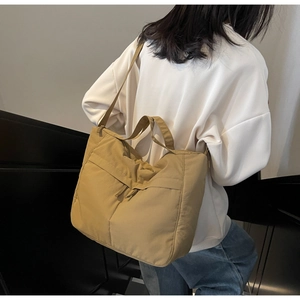 Khaki nylon tote bag with large capacity and dual straps shown on model for daily commute