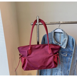 Détail du sac cabas en nylon bordeaux avec cordon et poignées en cuir grainé